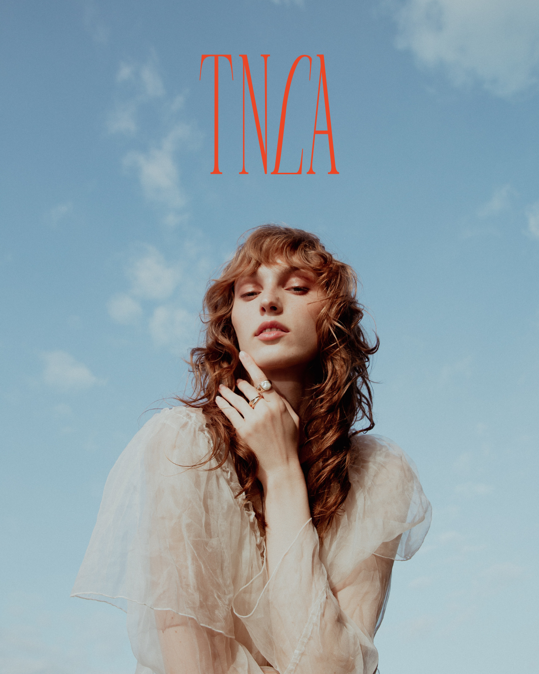 Ethereal portrait against blue sky with red text TNCA overlaid.