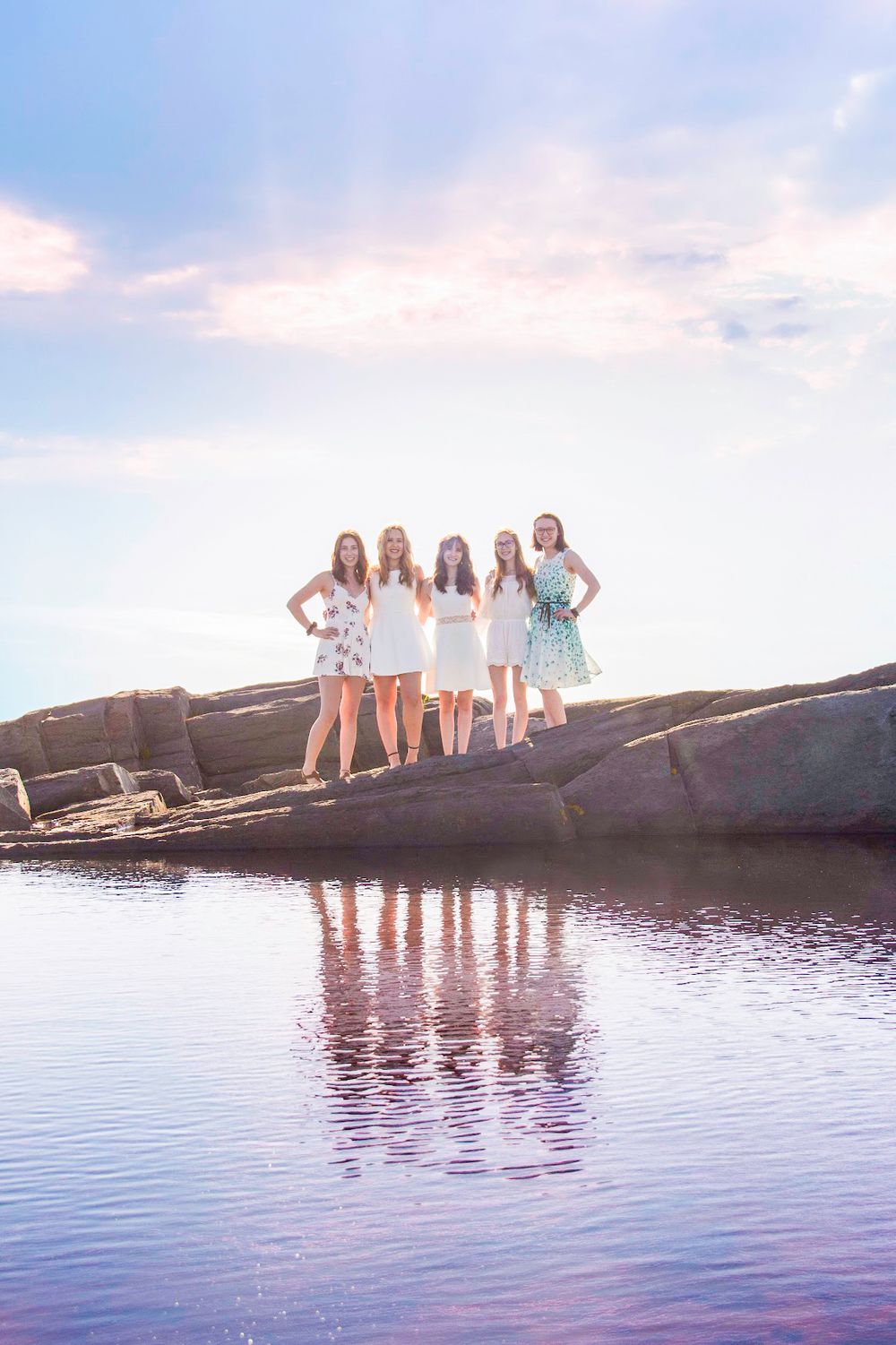 Girls' graduation portrait photo taken across the water to show their reflection at Cape Forchu, Yarmouth