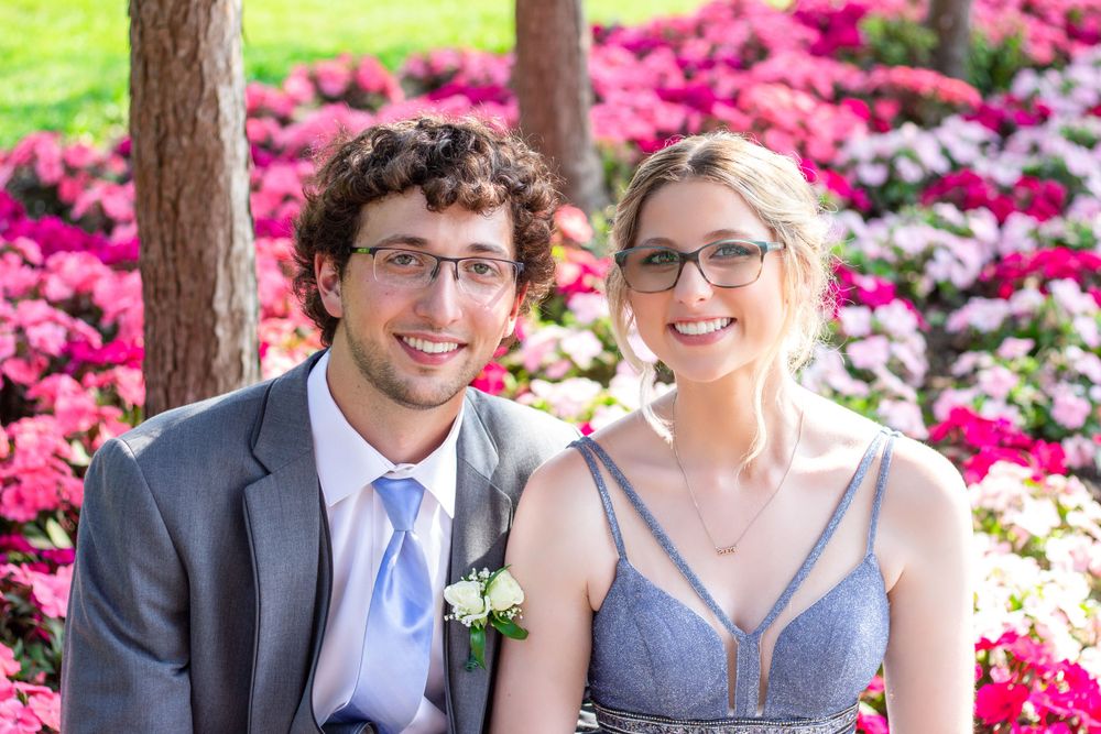 Portrait photo of a happy prom couple surrounded by beautiful flowers in Frost Park, Yarmouth
