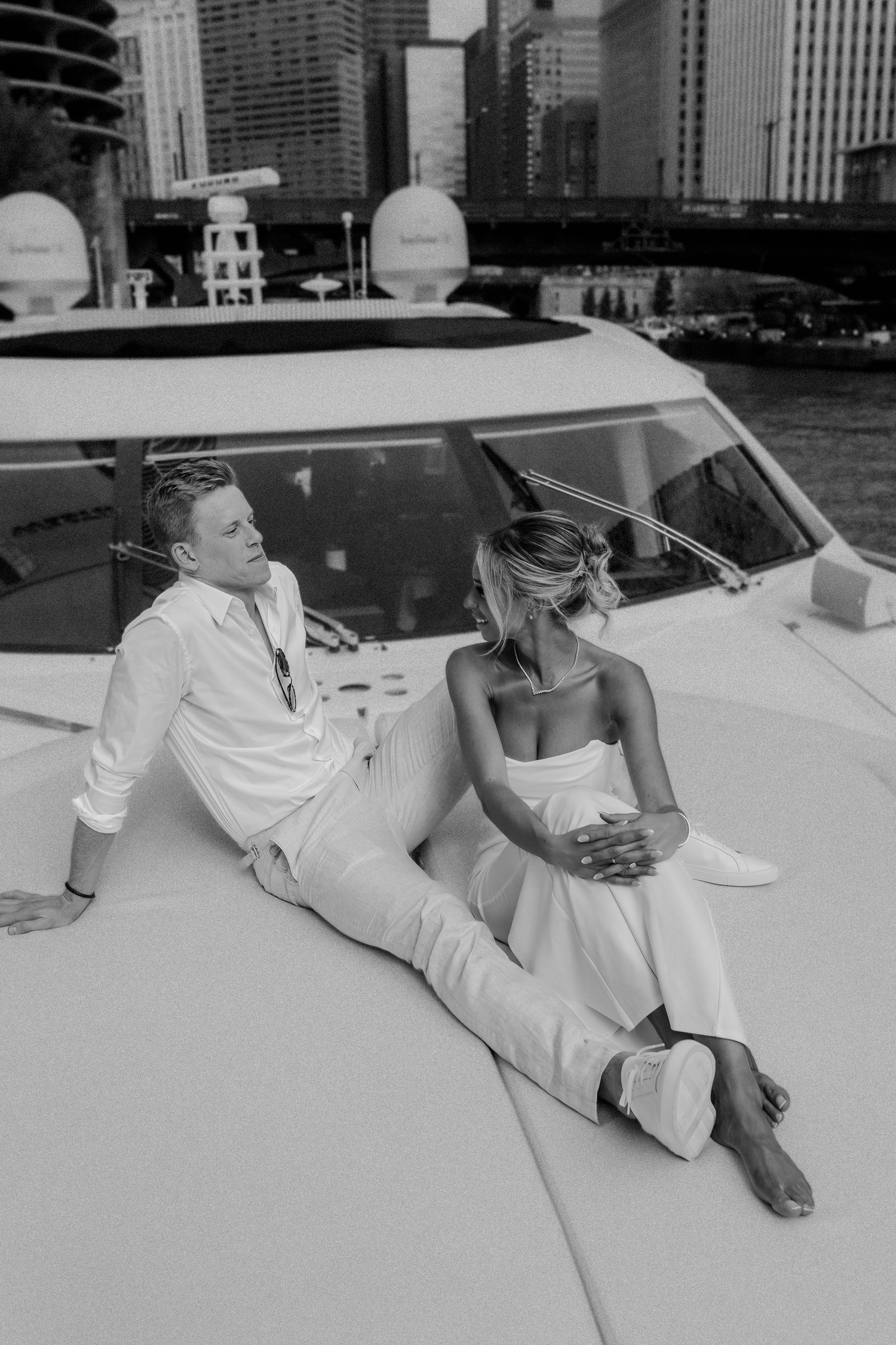 A couple relaxes on a boat deck with Chicago's skyline visible in the background.