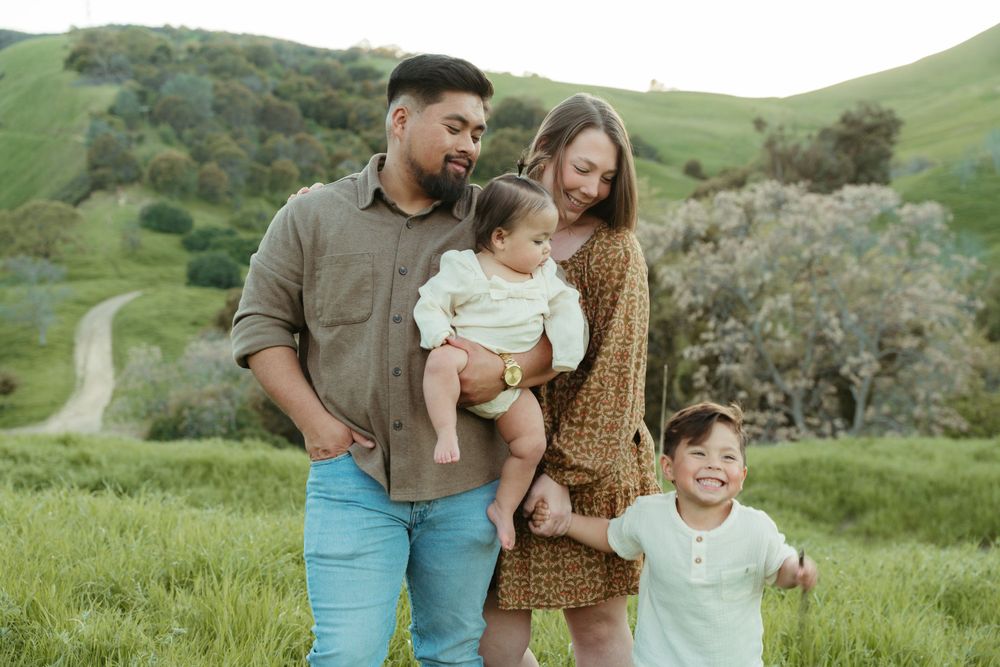 Sweet family photoshoot in a lush green hillside with winding path behind them  at Antioch, CA
