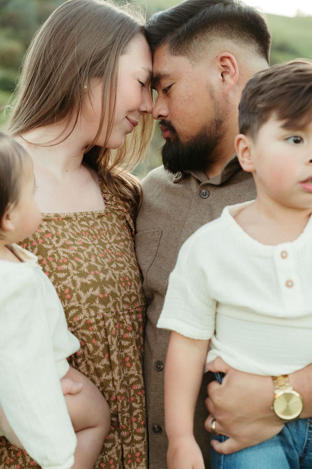 Intimate family portrait with everyone close together on a grassy hillside  at Antioch, CA