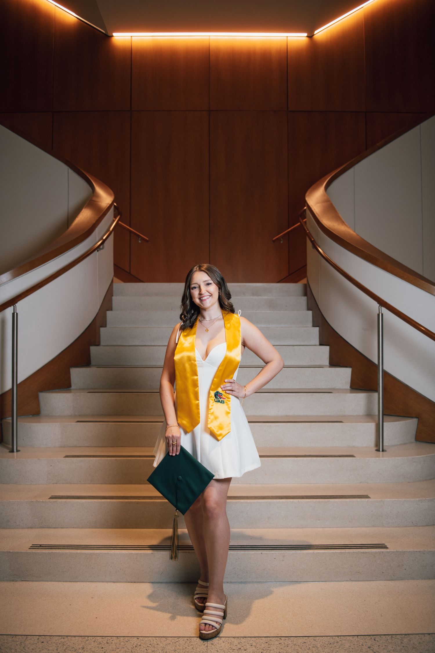UAB graduate posing in front of staircase, Birmingham Alabama senior portraits, affordable senior portrait photographer.