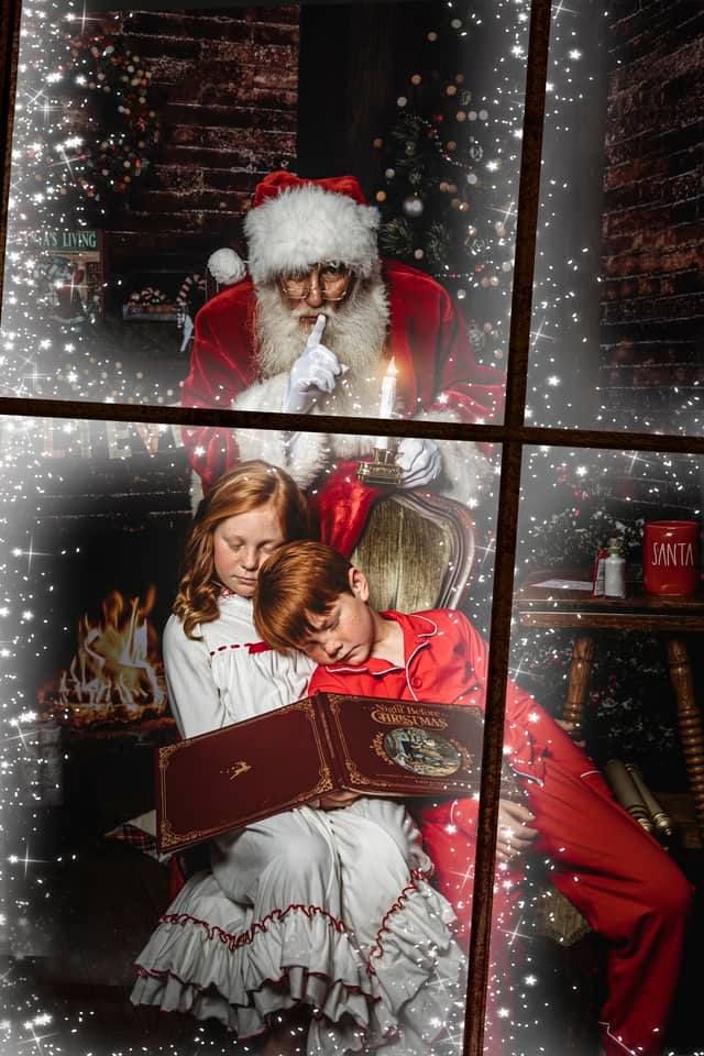 Children in holiday attire read a book by a frosty window while a Santa looks on overhead.  Middle TN Child Photographer