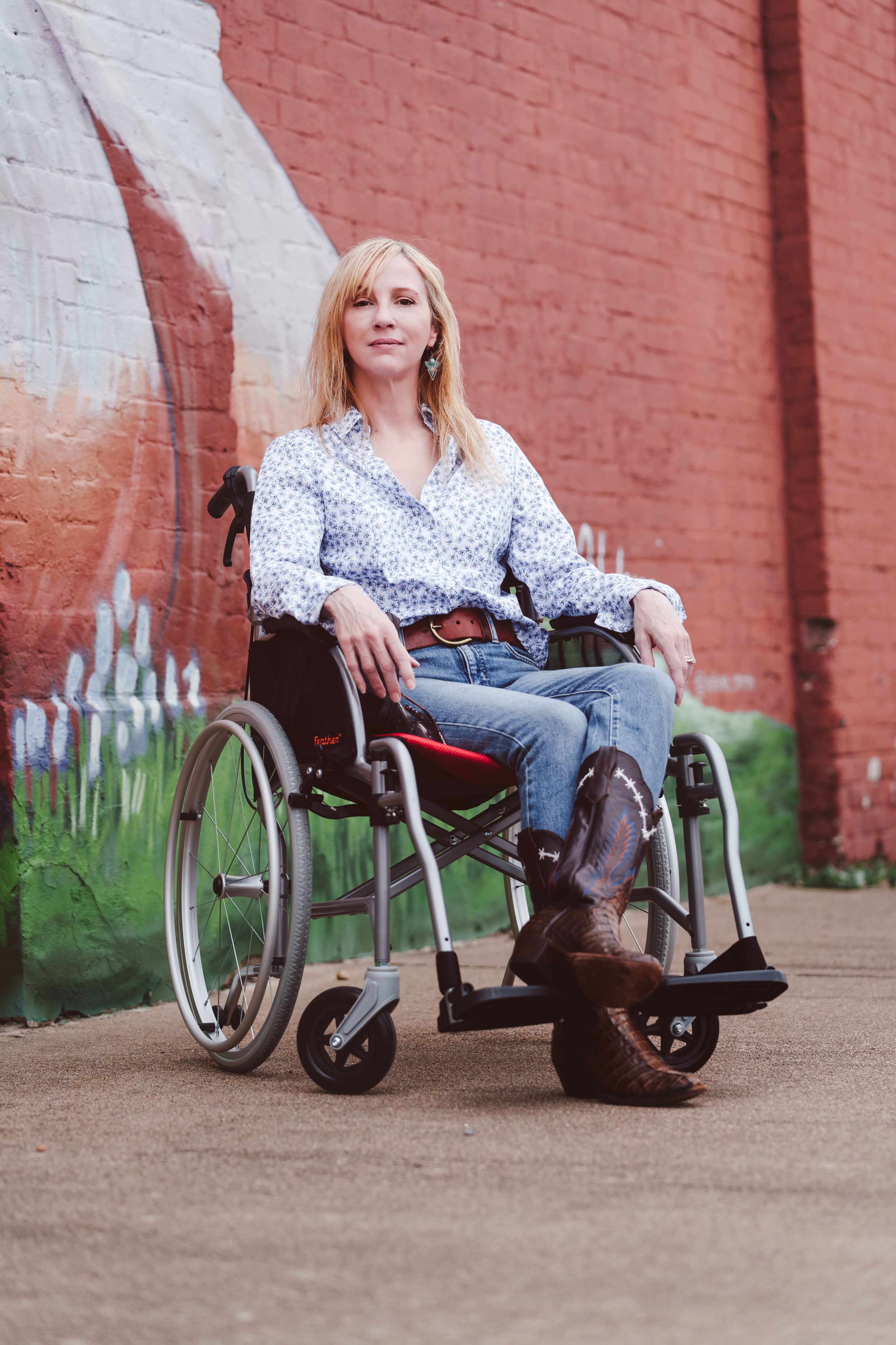 A person in a wheelchair wearing jeans and polka dot top poses against a brick wall in a multi-frame photo series.