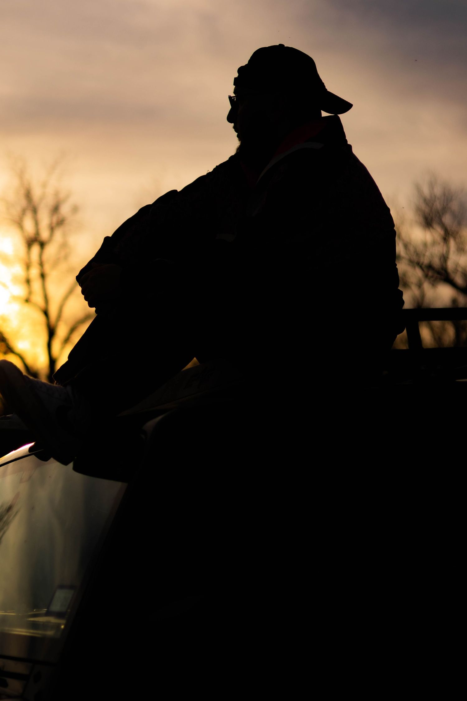 Someone wearing a leather jacket and red bandana leads another person by the hand in an outdoor setting.