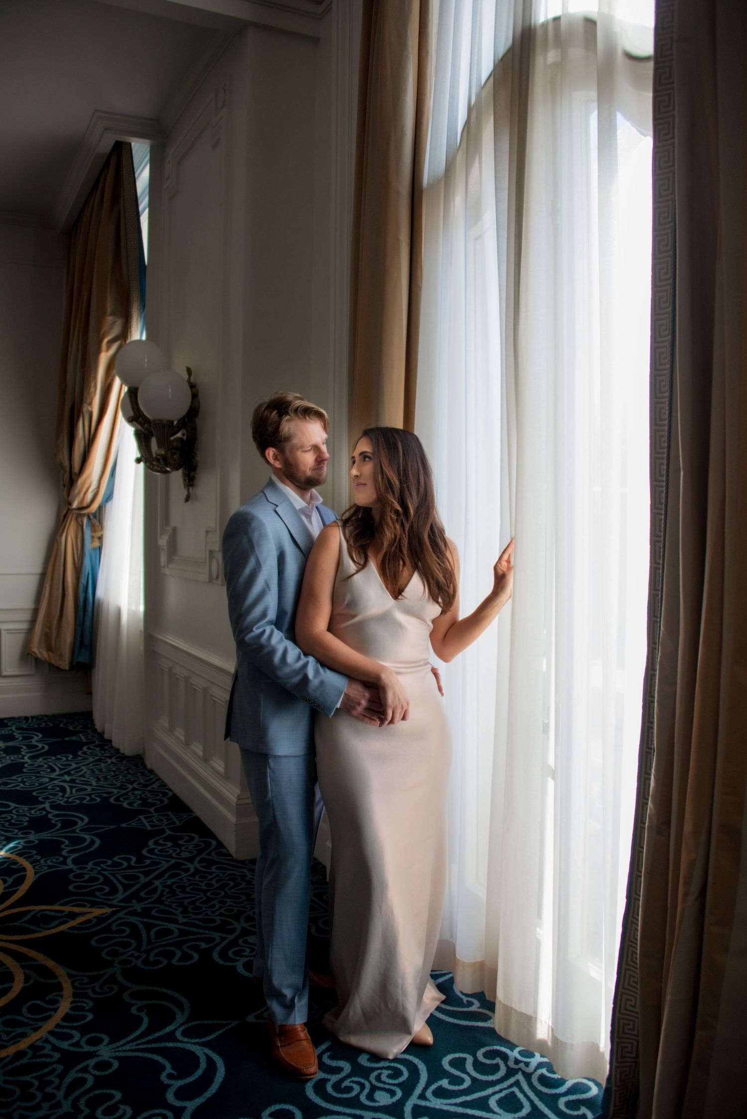 Man and woman near large window in ornate building