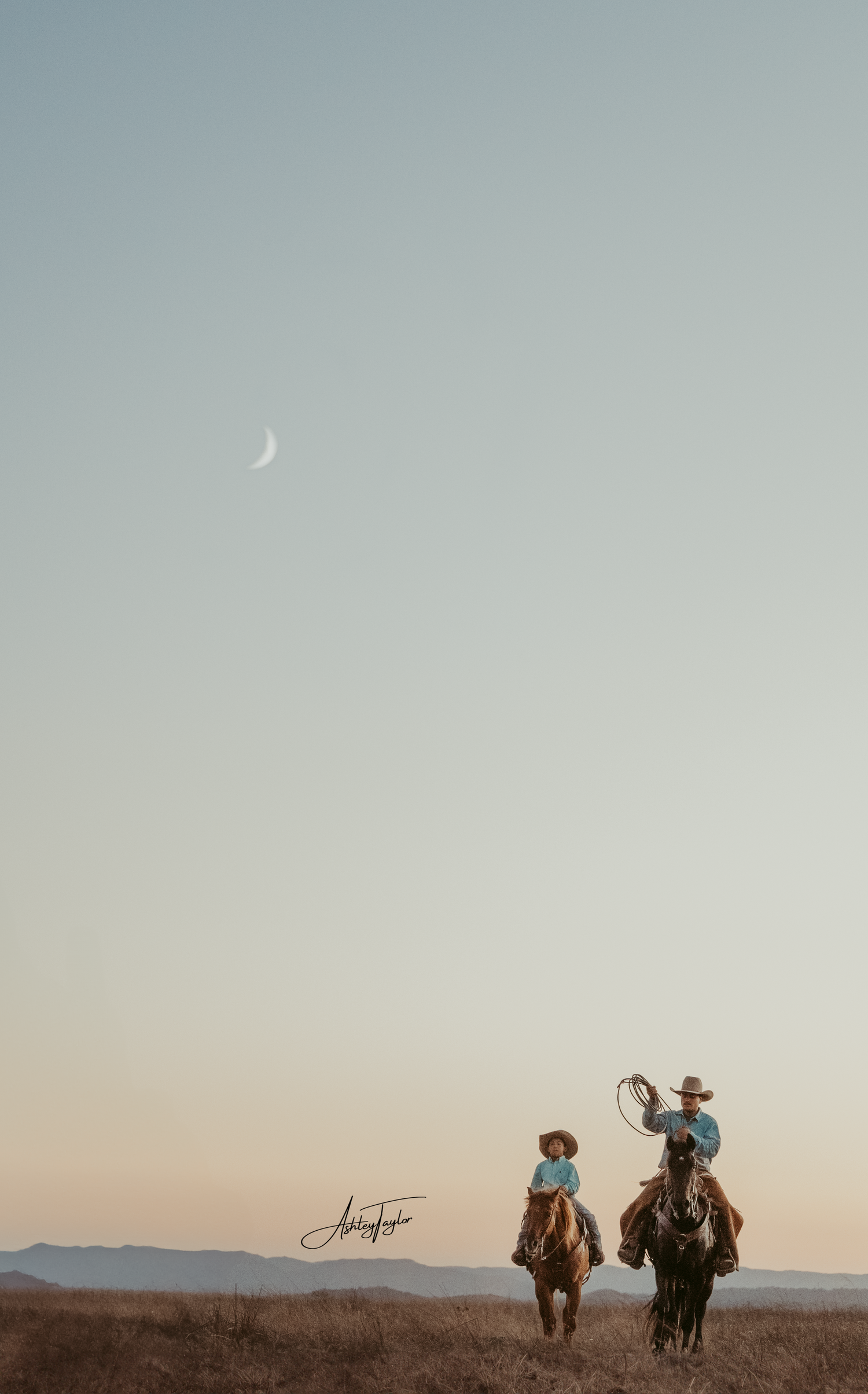 Two Cowboy's on horseback under crescent moon in desert landscape at dusk.