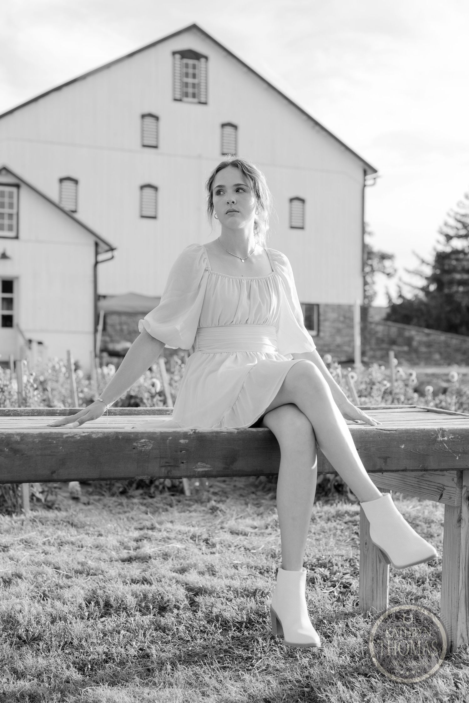 Classic black and white portrait showcases vintage style against rustic barn background.