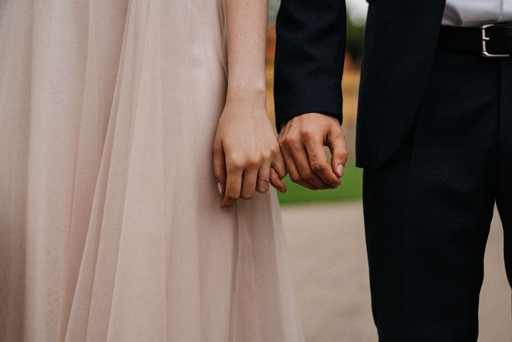 A romantic wedding moment captured in soft blush tones with elegant attire and delicate details.