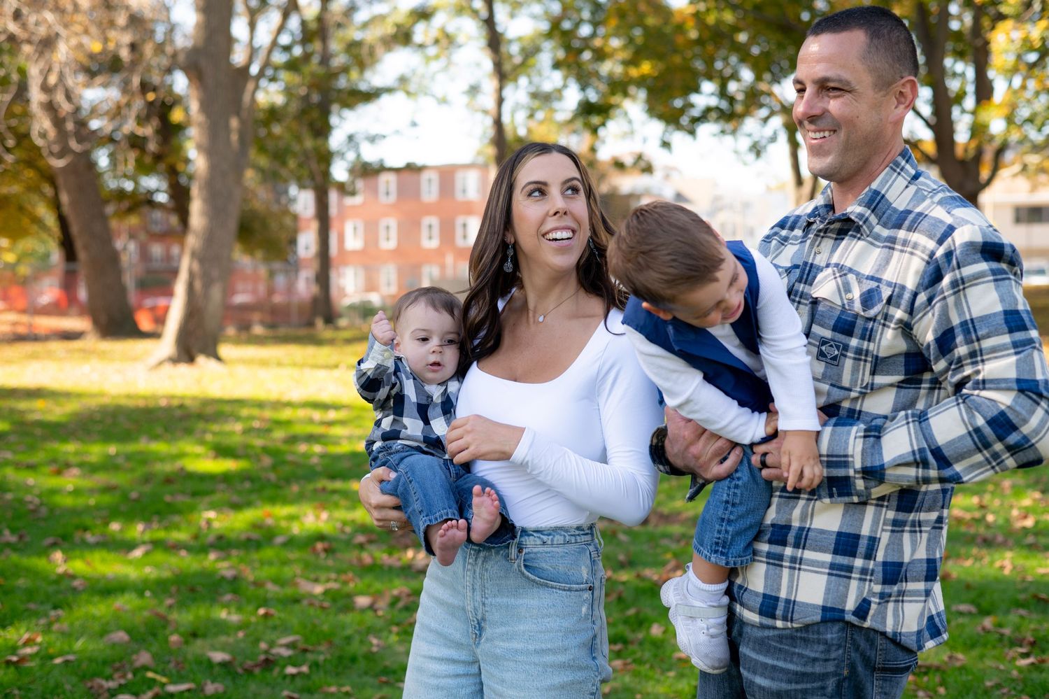 Family enjoying an autumn day together in a park with fall foliage.