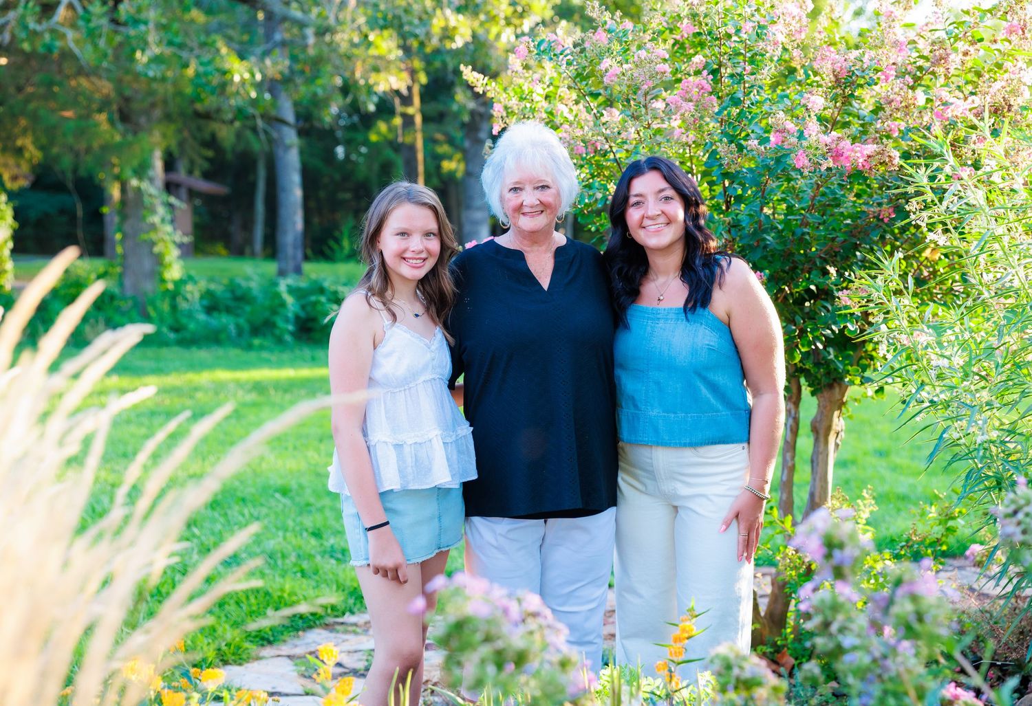 Grandma taking family pictures at Table Rock Lake with family near pink tree.