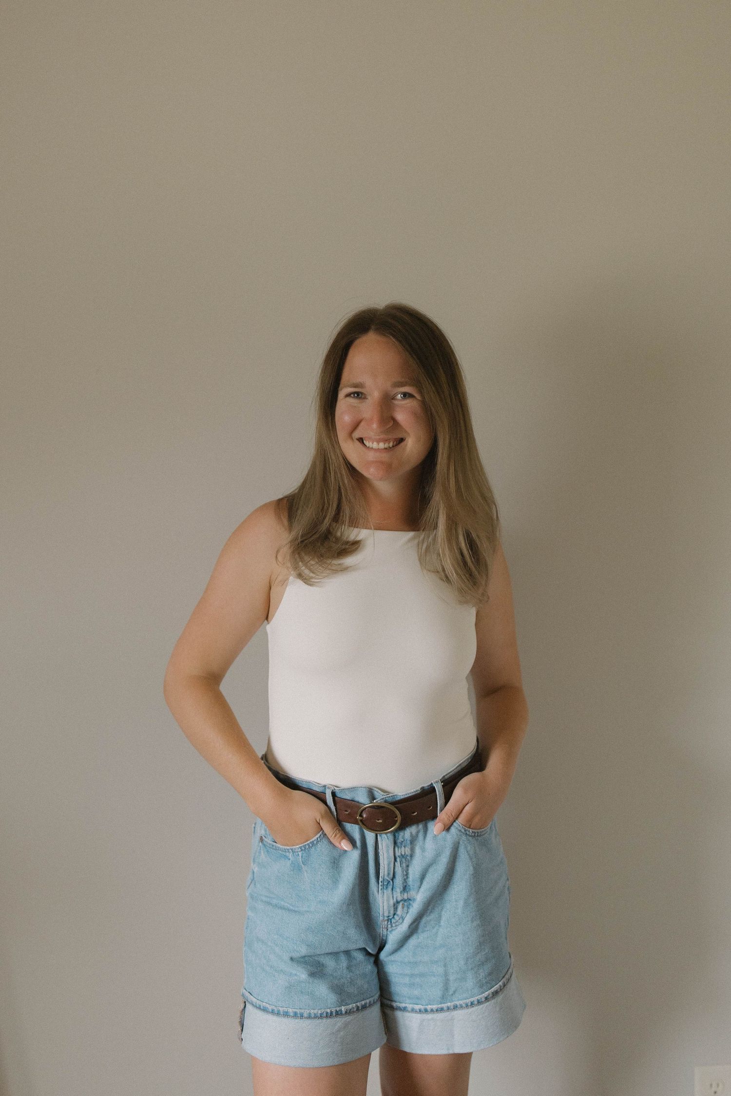 A series of casual fashion poses showing denim shorts paired with a white sleeveless top.