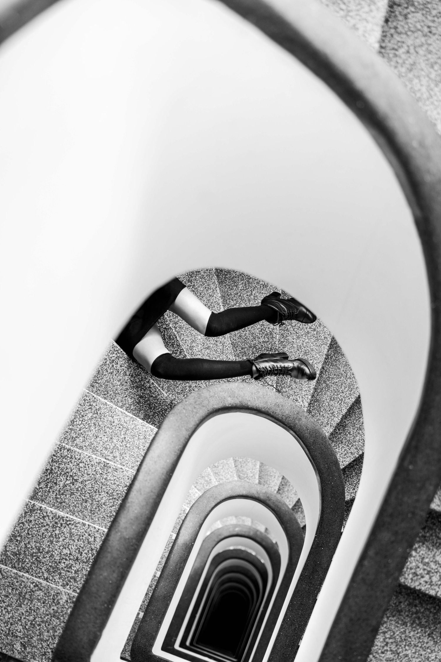 Abstract spiral staircase photographed in black and white from above.