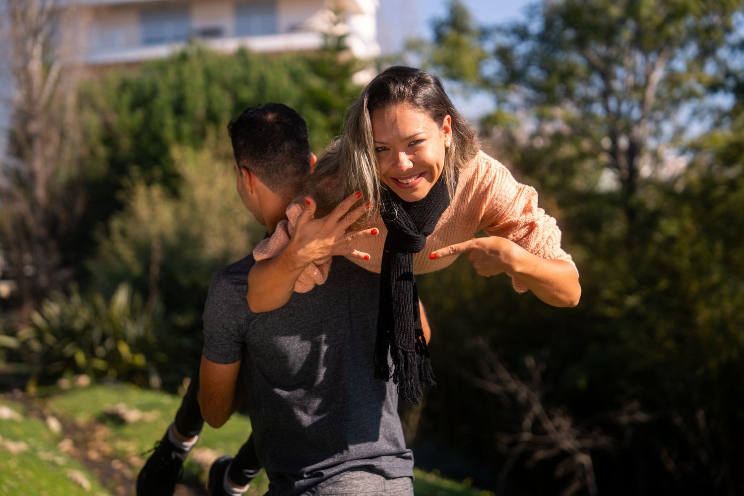 A romantic marriage proposal moment unfolds in a sunny outdoor setting.