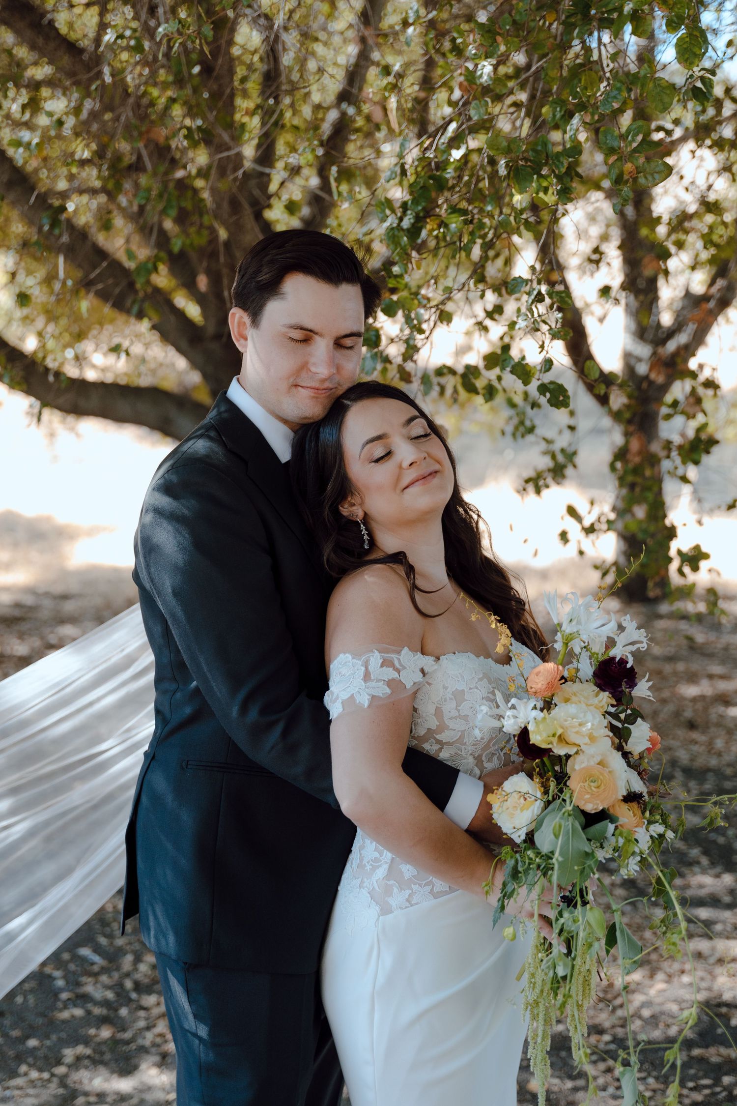 Bridal portraits of a just-married couple walking hand in hand. The ocean and their alter in the background.