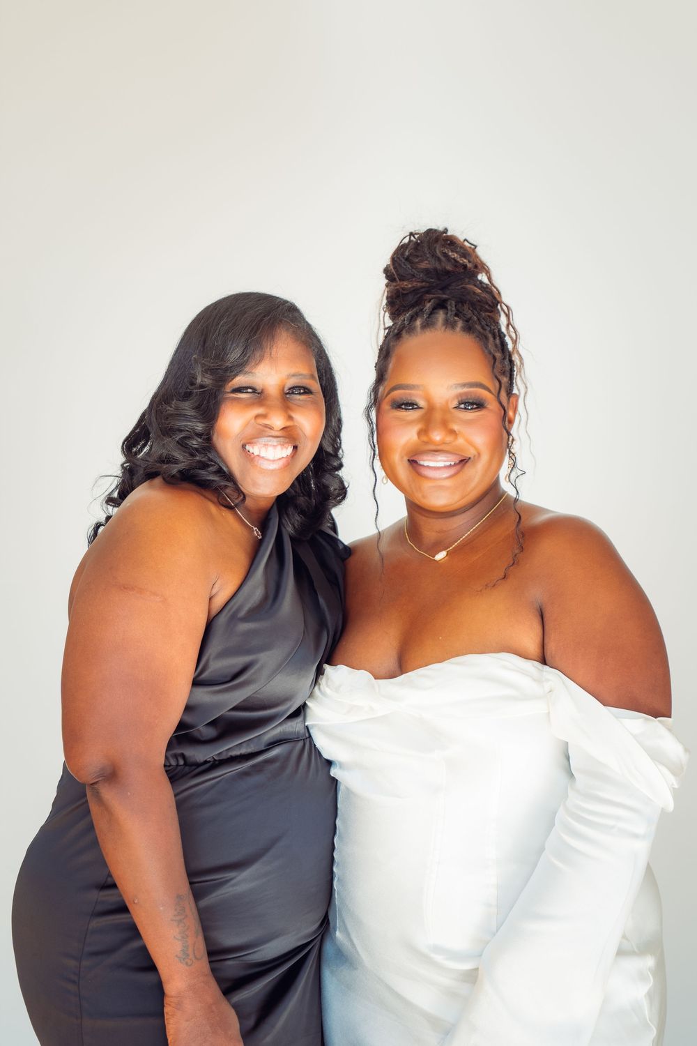 Two friends pose together in contrasting black and white outfits for a fun photoshoot series.