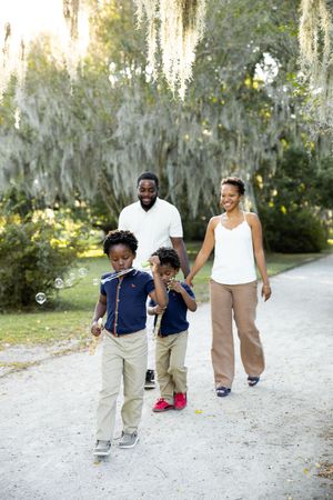 A series of playful moments captured on a sandy path under hanging Spanish moss trees.