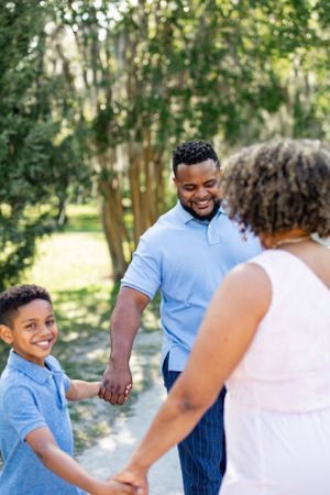 A happy family moment captured while playing together on a wooded path.