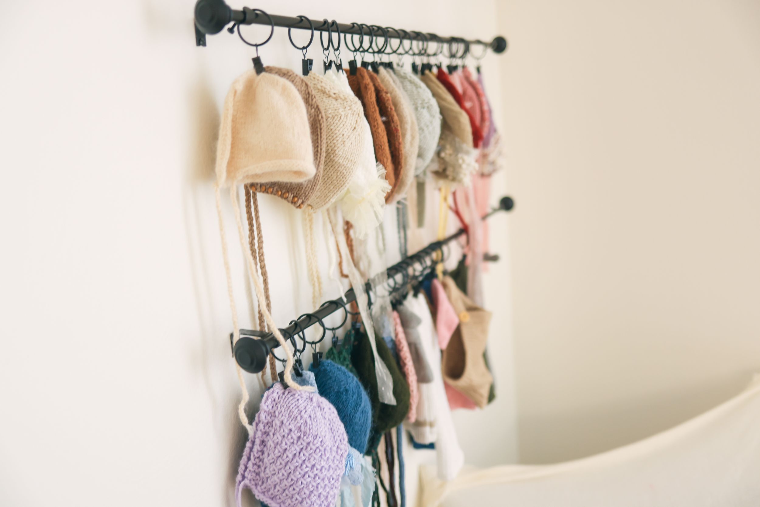 Clothing rack with hangers displaying various garments in neutral tones.