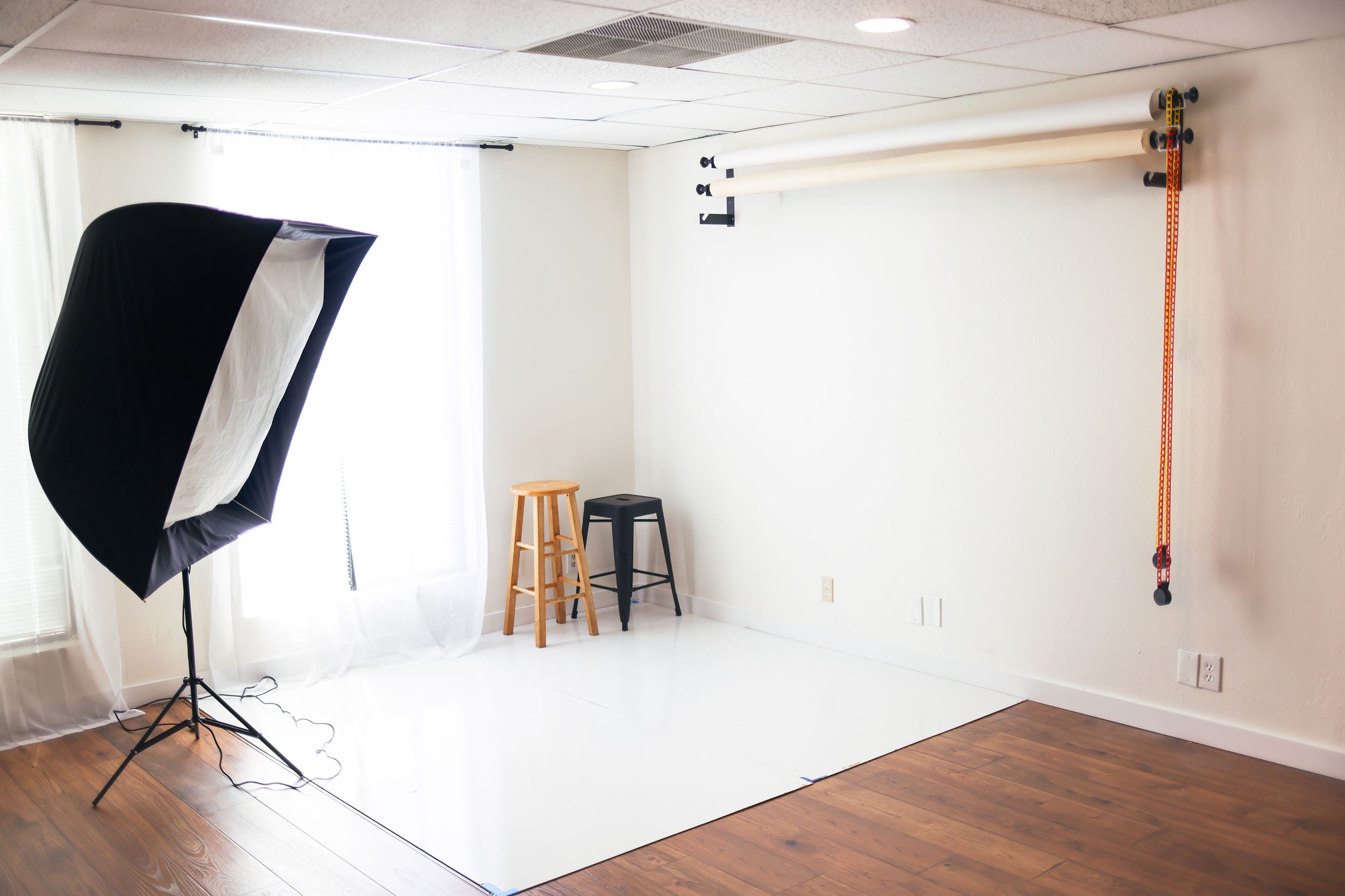 Professional photography studio setup with white backdrop and softbox lighting.