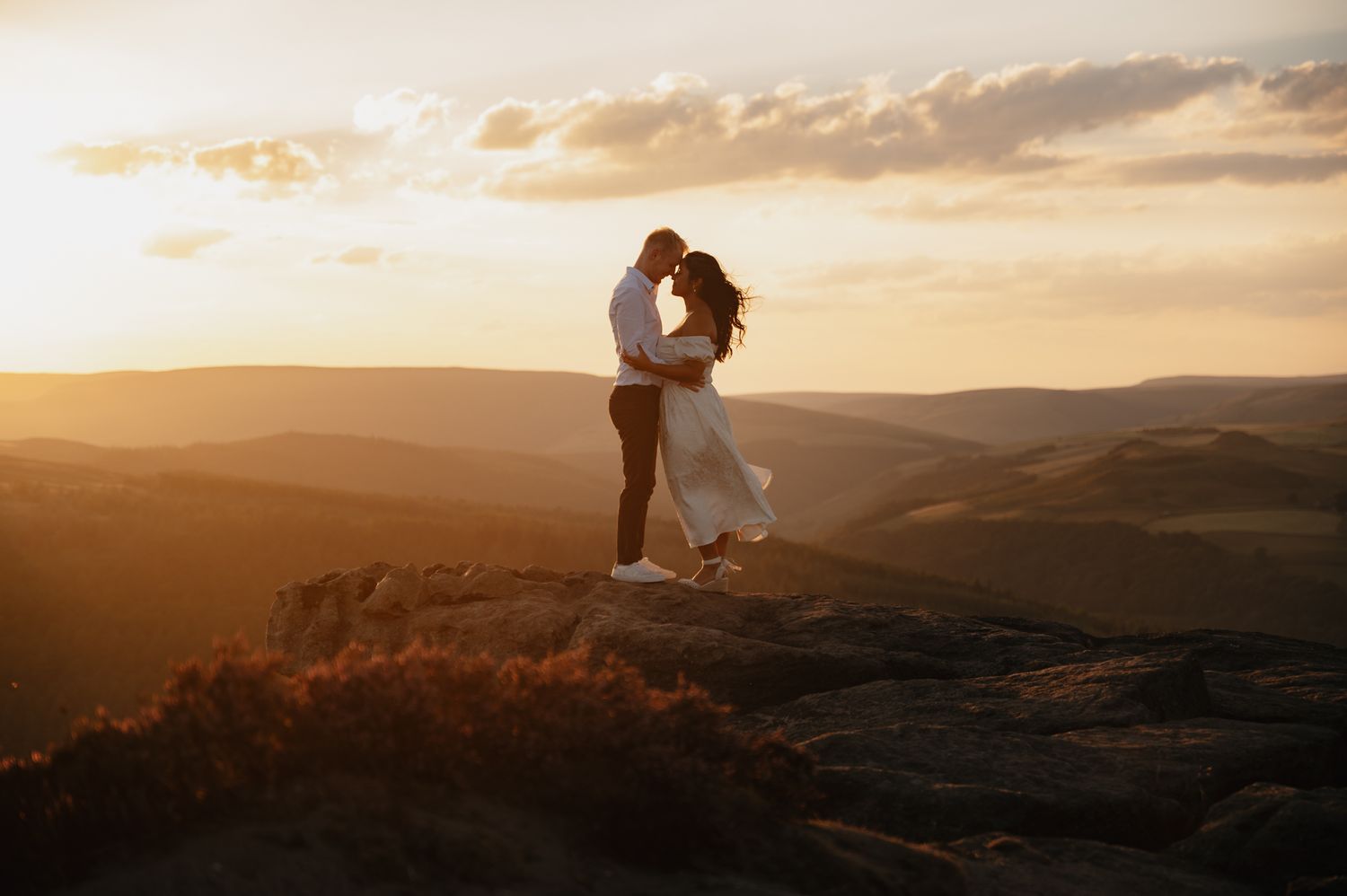 Panoramic view of golden hour in the Blue Ridge Mountains with hikers resting at scenic overlook.