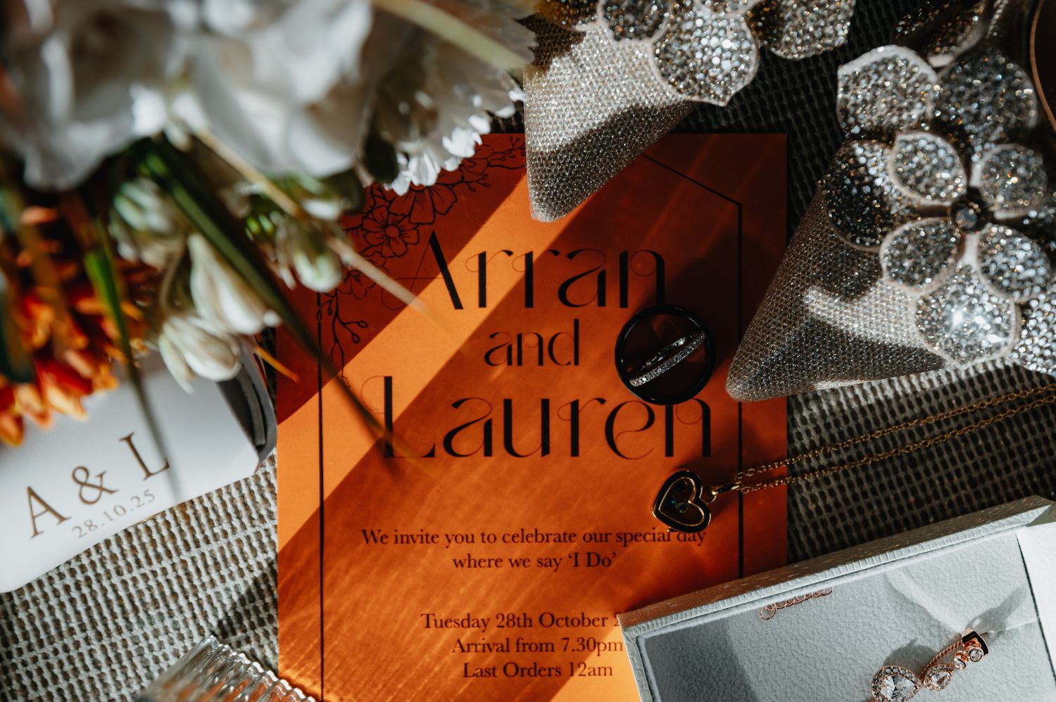 Elegant black lace and orange fashion magazine pages arranged artistically in moody lighting.