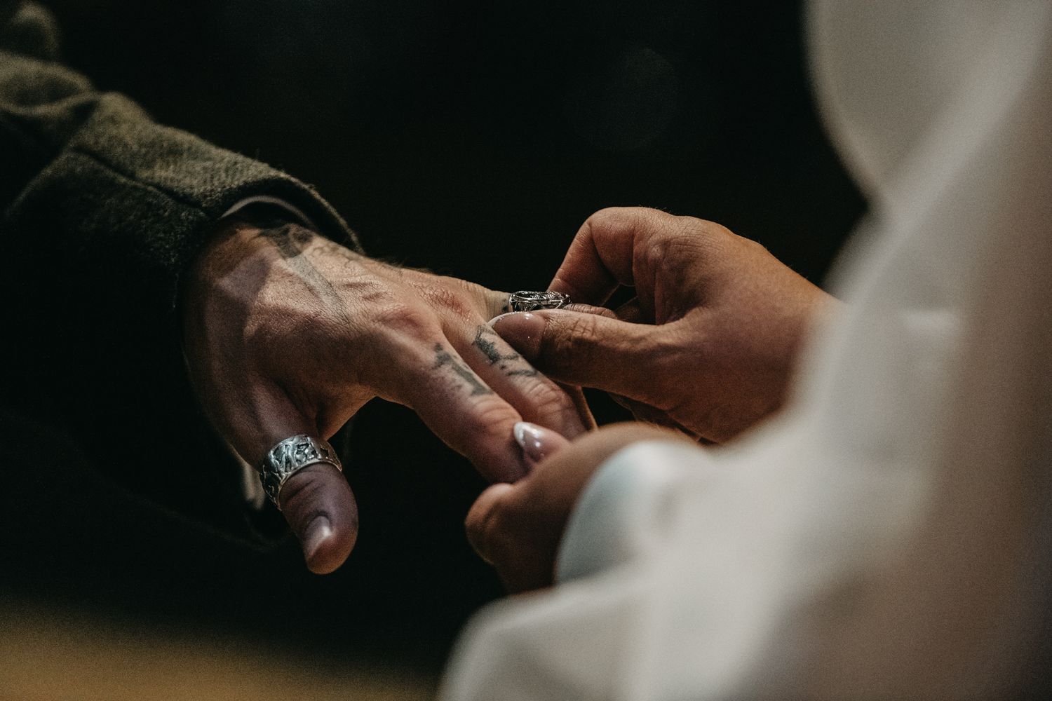 Intimate close-up shots of hands exchanging rings during a wedding ceremony.