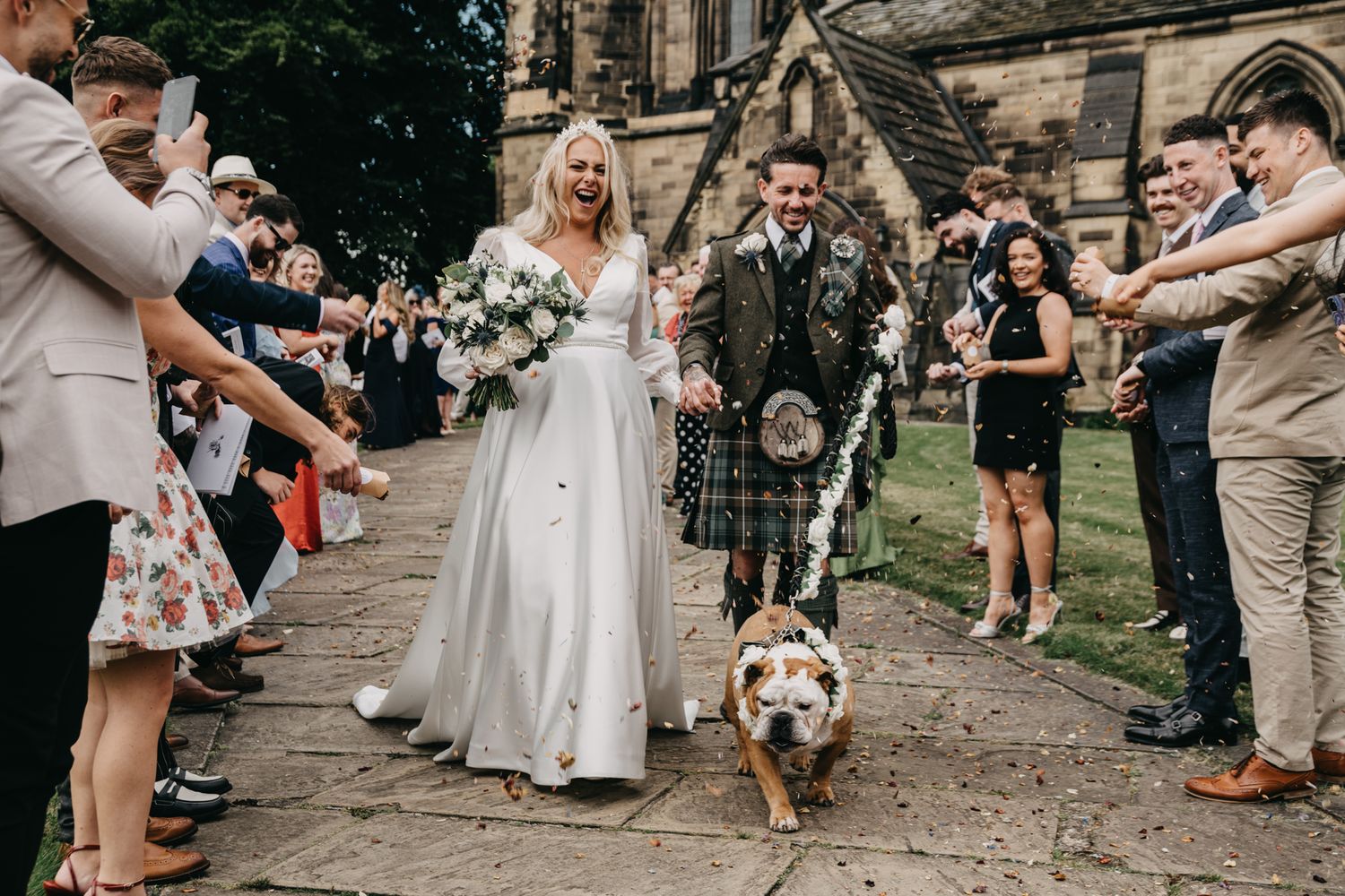 Guests celebrating outside a historic church during a wedding ceremony.
