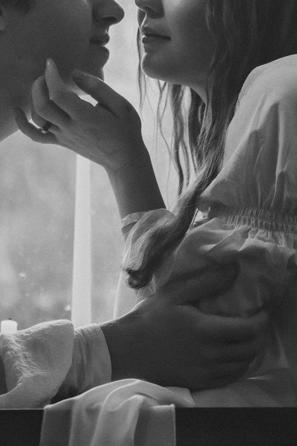 Tight crop focus on a woman and man delicately embracing with hands, edited in black and white, during a romance styled session near Tacoma.