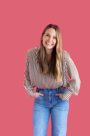 A series of candid fashion photos showing a person in a striped top and blue jeans against a pink background.