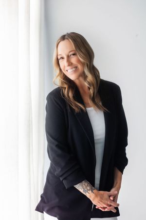 Professional headshots showing person in black blazer and white top against light background.