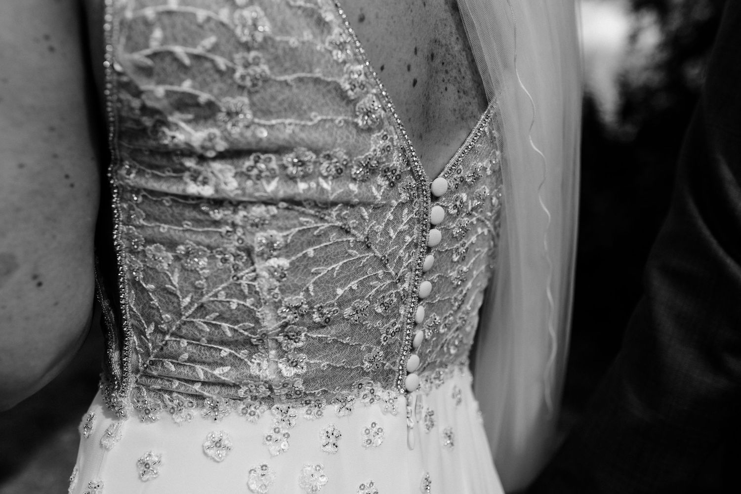 Close-up detail of an elegant beaded wedding dress bodice in black and white.