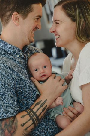 A series of intimate family photos showing parents holding their baby while sharing tender moments together.