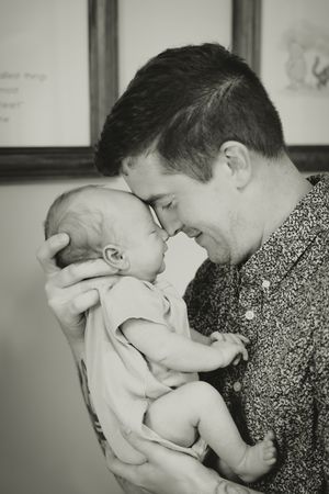 A tender black and white photo series showing a parent sharing loving moments with their baby.