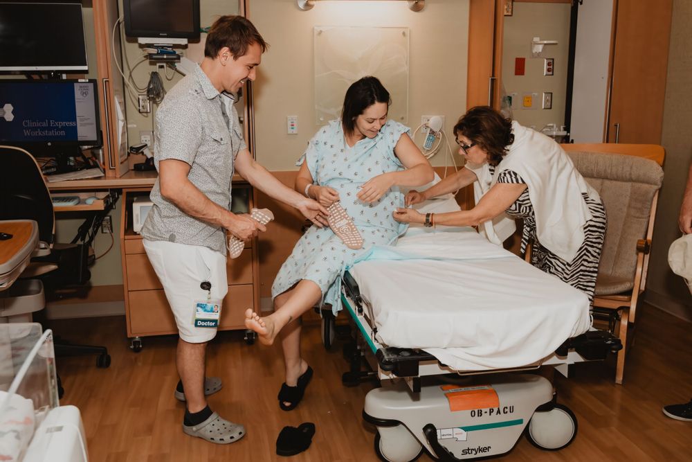 Birth support team assisting during labor in hospital delivery room.