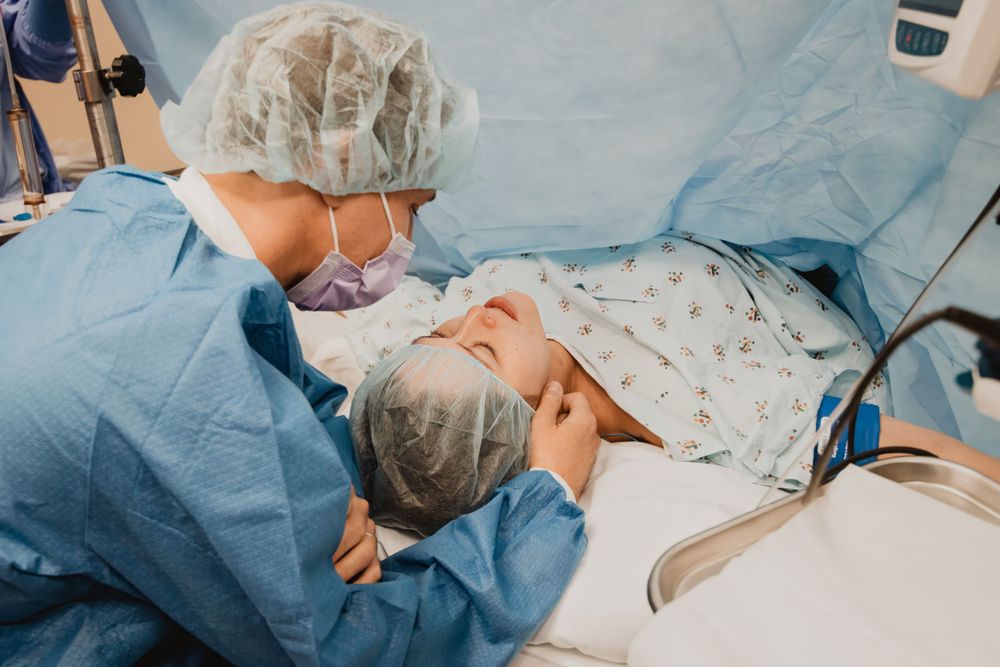 Medical professional in surgical gear performs a delicate procedure on a patient in a clinical environment.