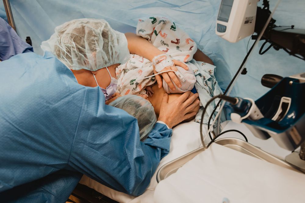 Medical practitioner in protective gear conducts a precise procedure in a clinical setting.