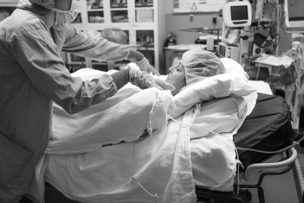 Black and white image of medical professionals during surgical procedure.