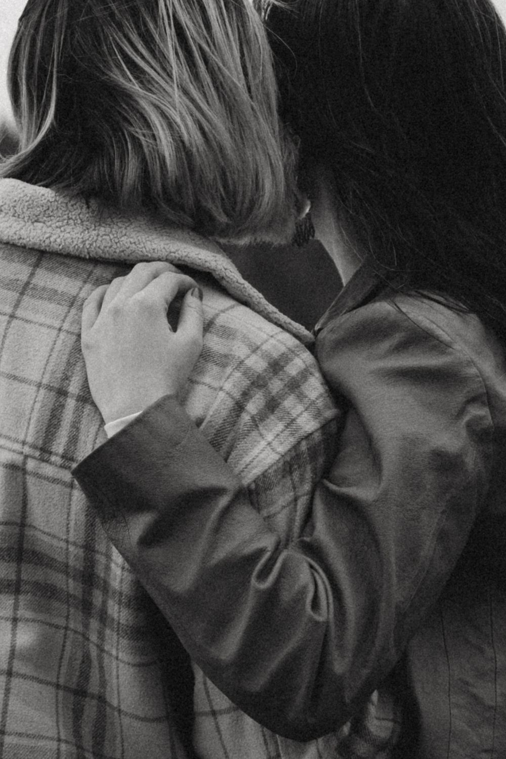 Close up black and white photo showing an intimate emotional embrace between two people.