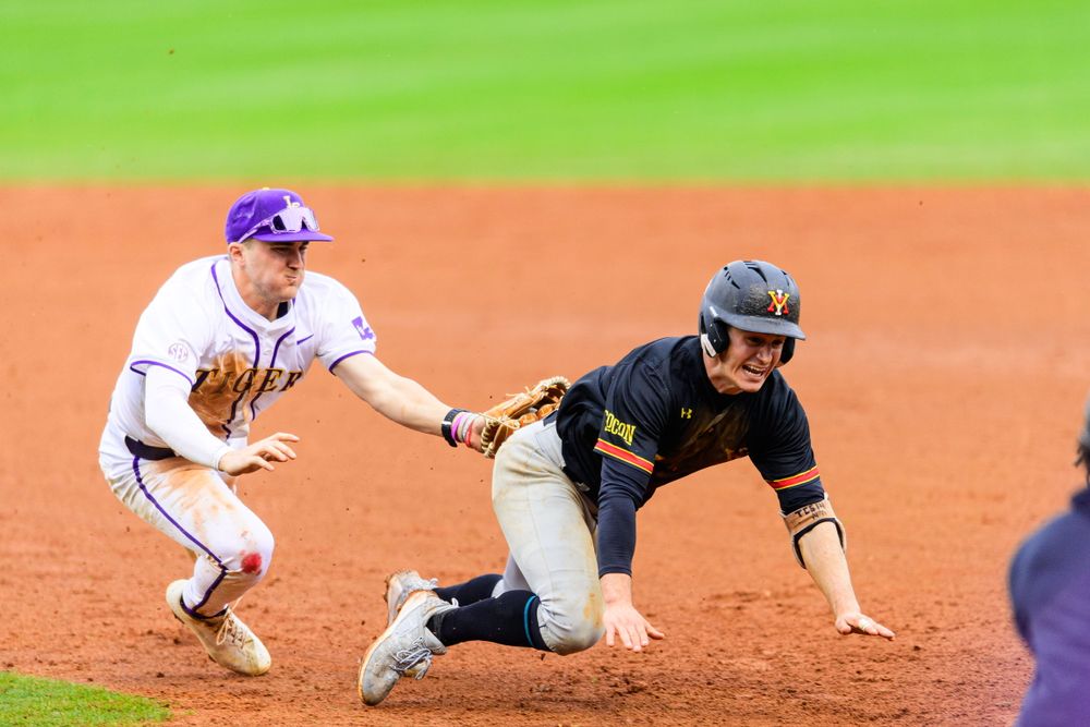 Baseball players engaged in a close play near first base during a game.