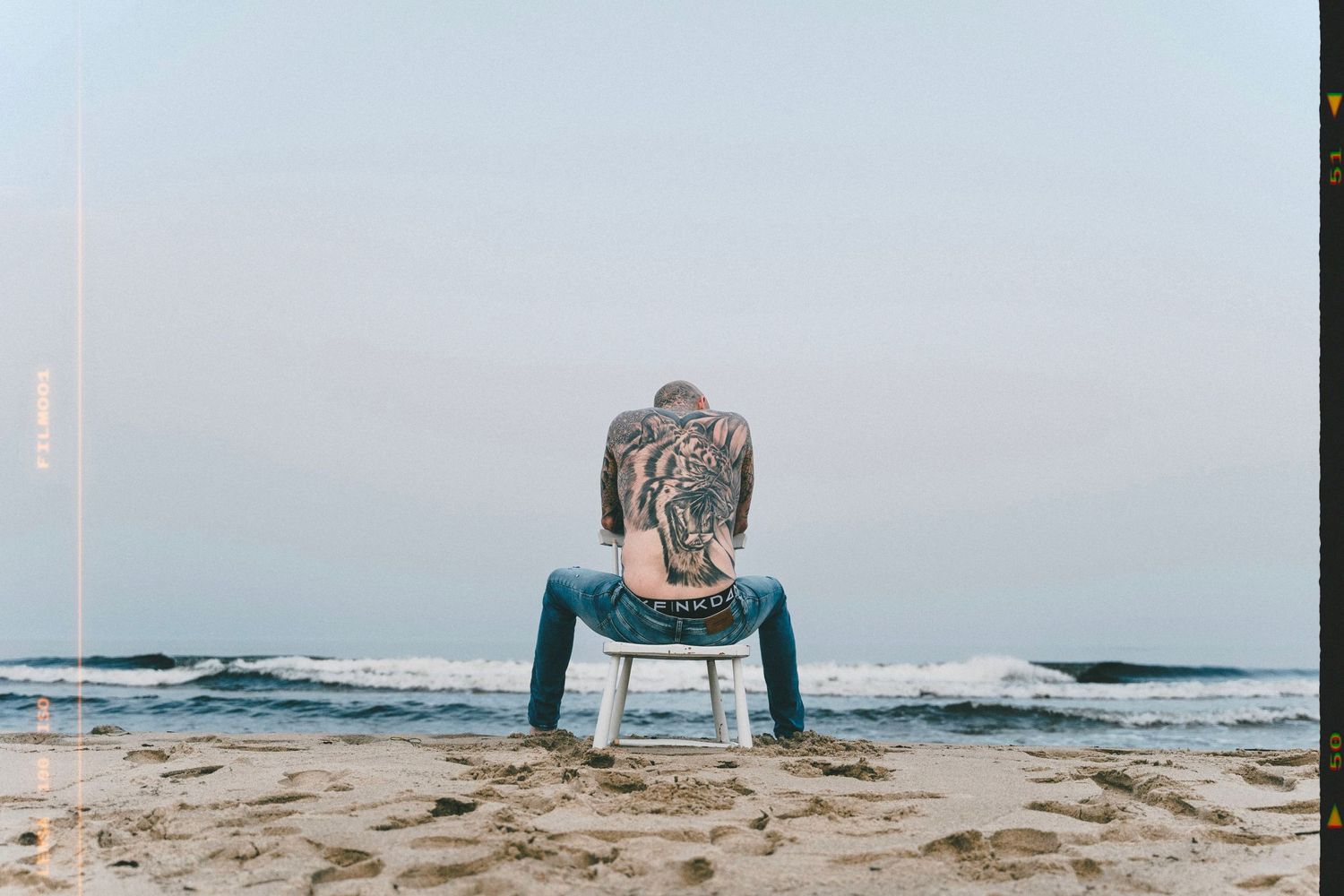 Porträtt med hav, vind och natur – fotografering Österlen. Tatuerad modell