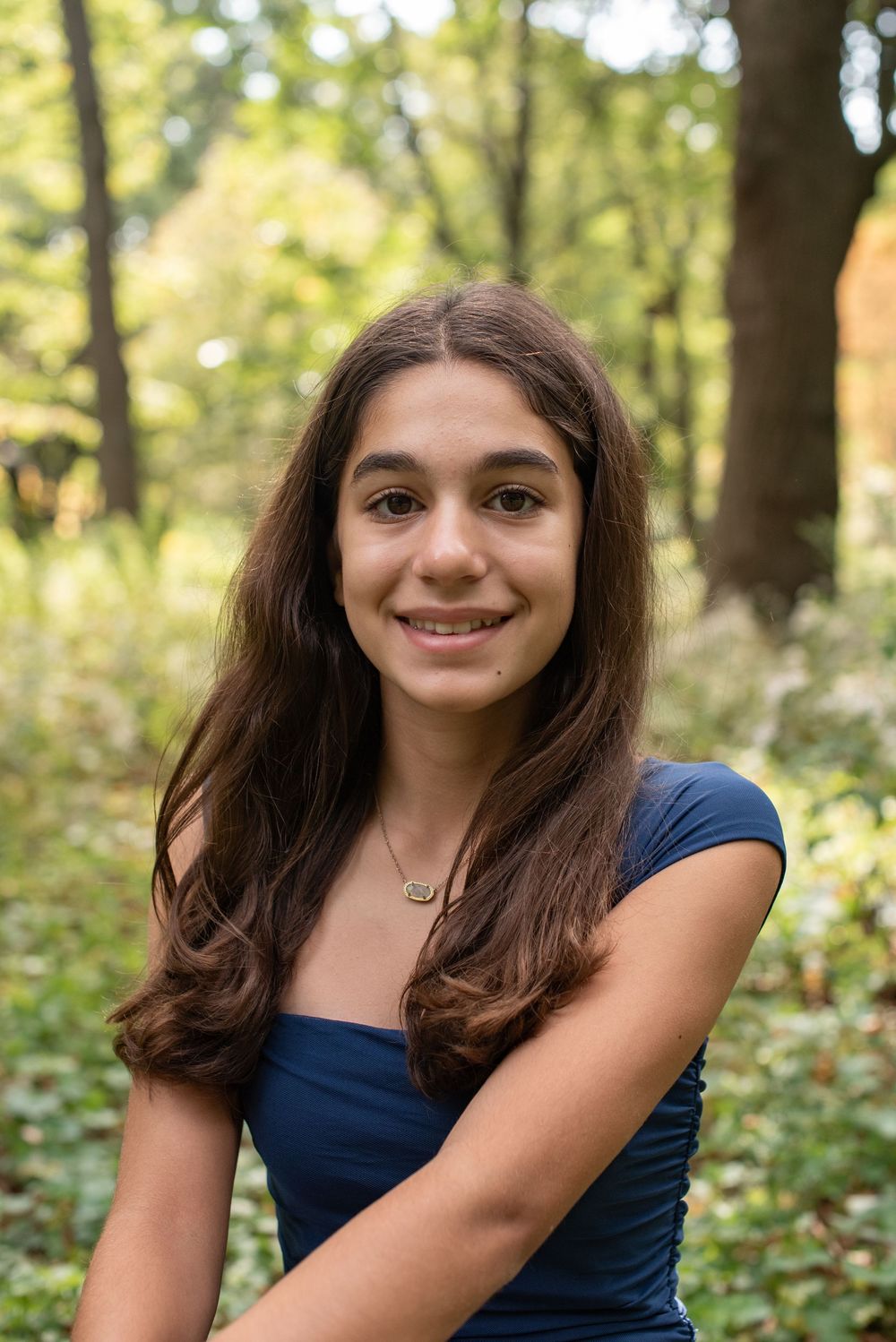 A series of outdoor portrait photos showing someone in a navy blue top against a blurred natural background.