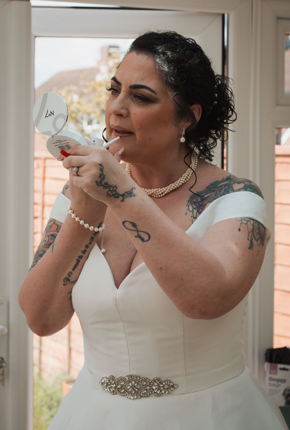 Bride applying lipstick in a mirror at Portsmouth wedding by Shayla Bloom Photography