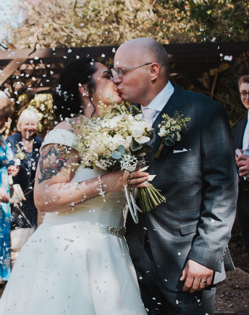 Bride and groom sharing a kiss under flurries of confetti at Portsmouth wedding by Shayla Bloom Photography