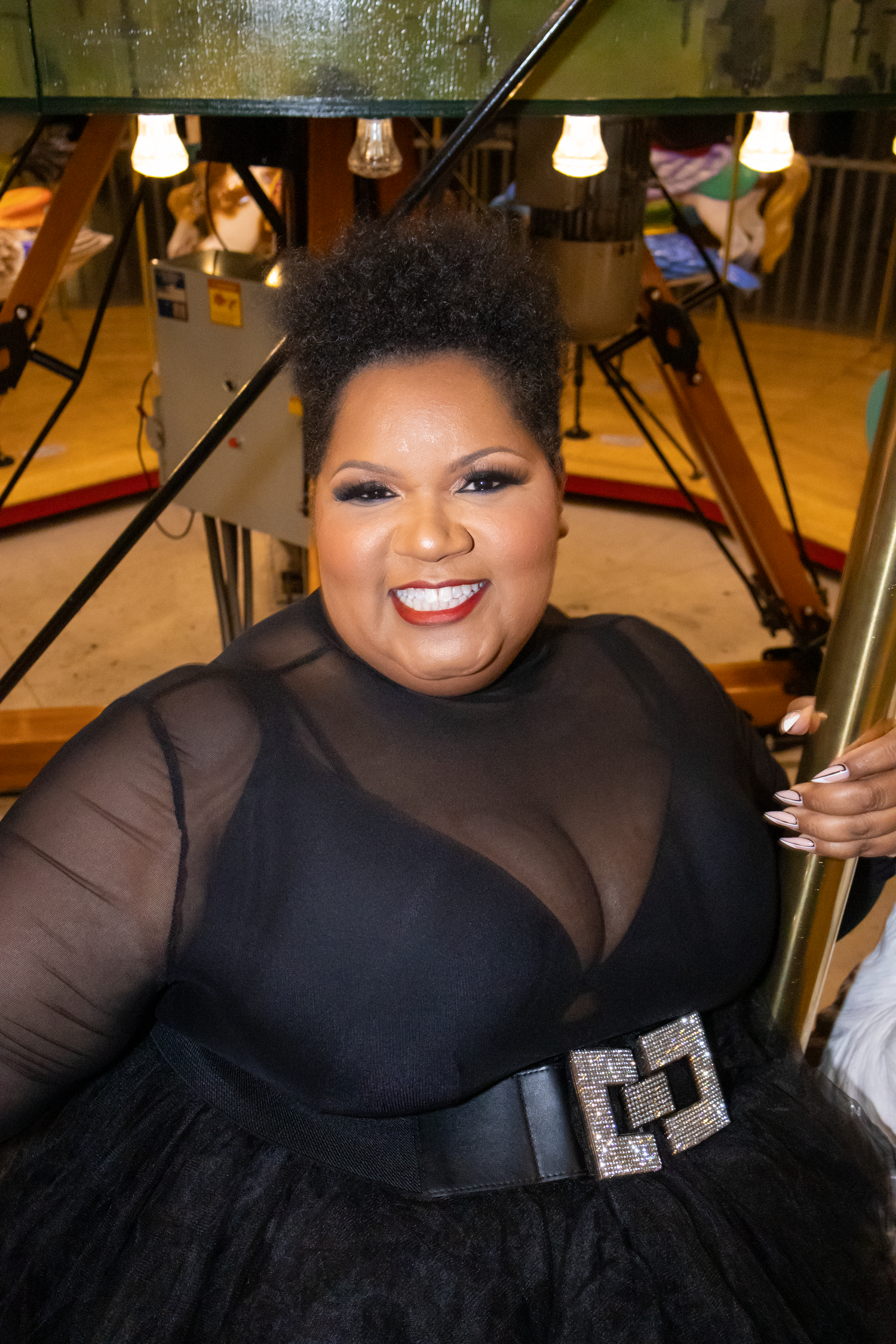 Person in elegant black formal gown posing with dramatic makeup and jewelry.