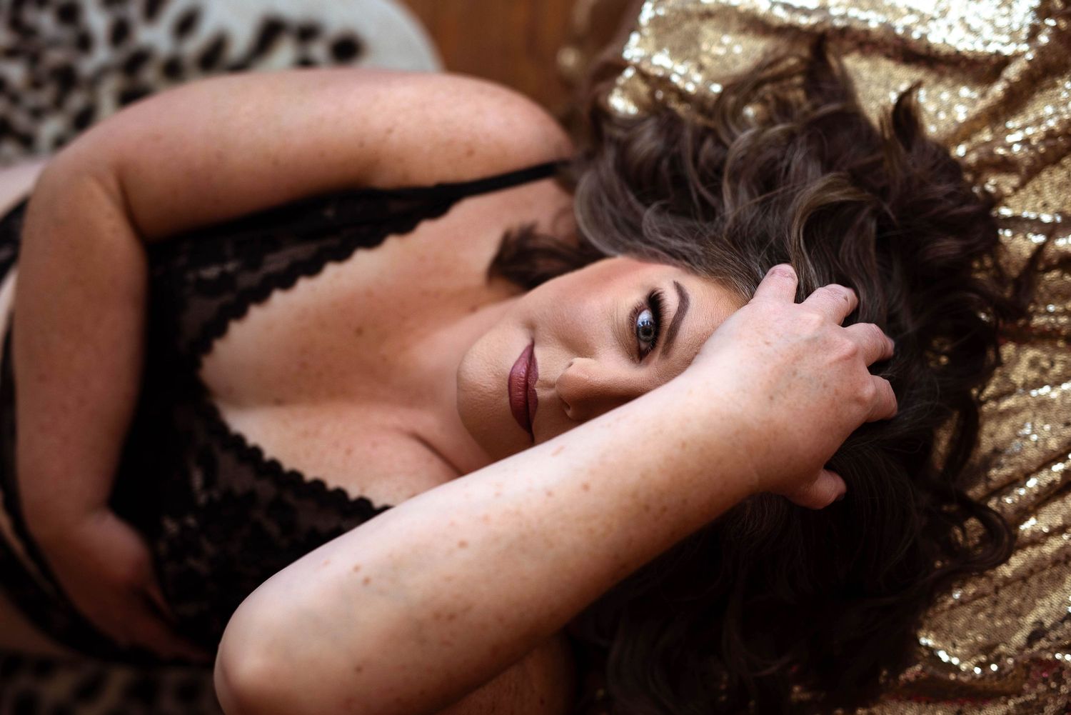 Elegant studio photo of dark curls styled against a glittering gold backdrop with dramatic shadows and poses.
