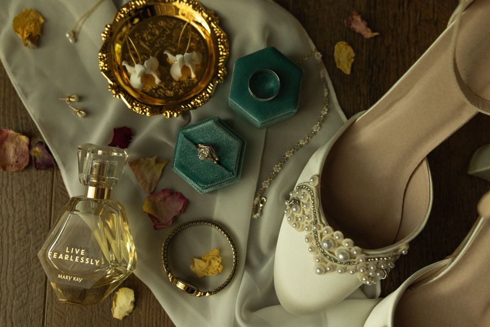 Vintage teacups, pearls, and white shoes arranged in an elegant shabby chic display with teal and gold accents.