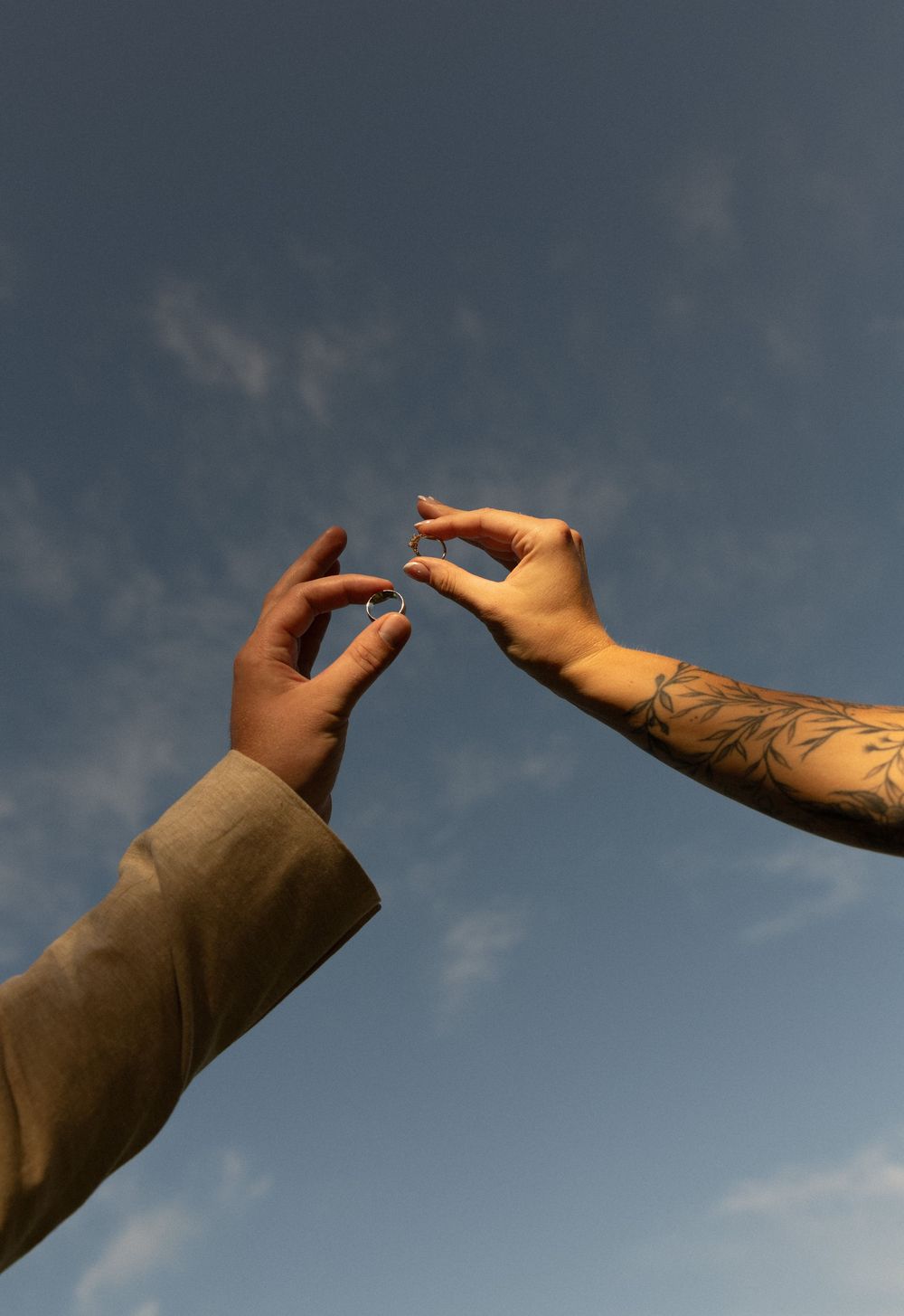A series of hands reaching upward against a moody cloudy sky background create a dramatic visual sequence.