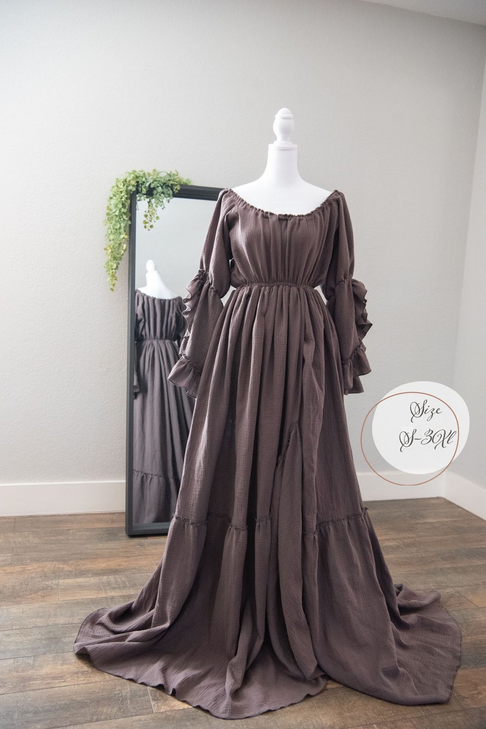 Deep brown off-shoulder maxi dress with gathered waist and dramatic train shown on display mannequin.